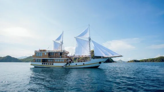 A traditional phinisi boat sails through the waters of Labuan Bajo. — Barakati Phinisi Sailing Adventure in Komodo